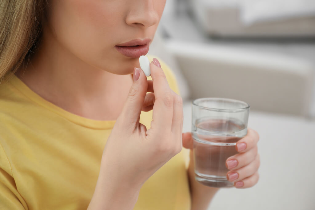 薬を飲む女性